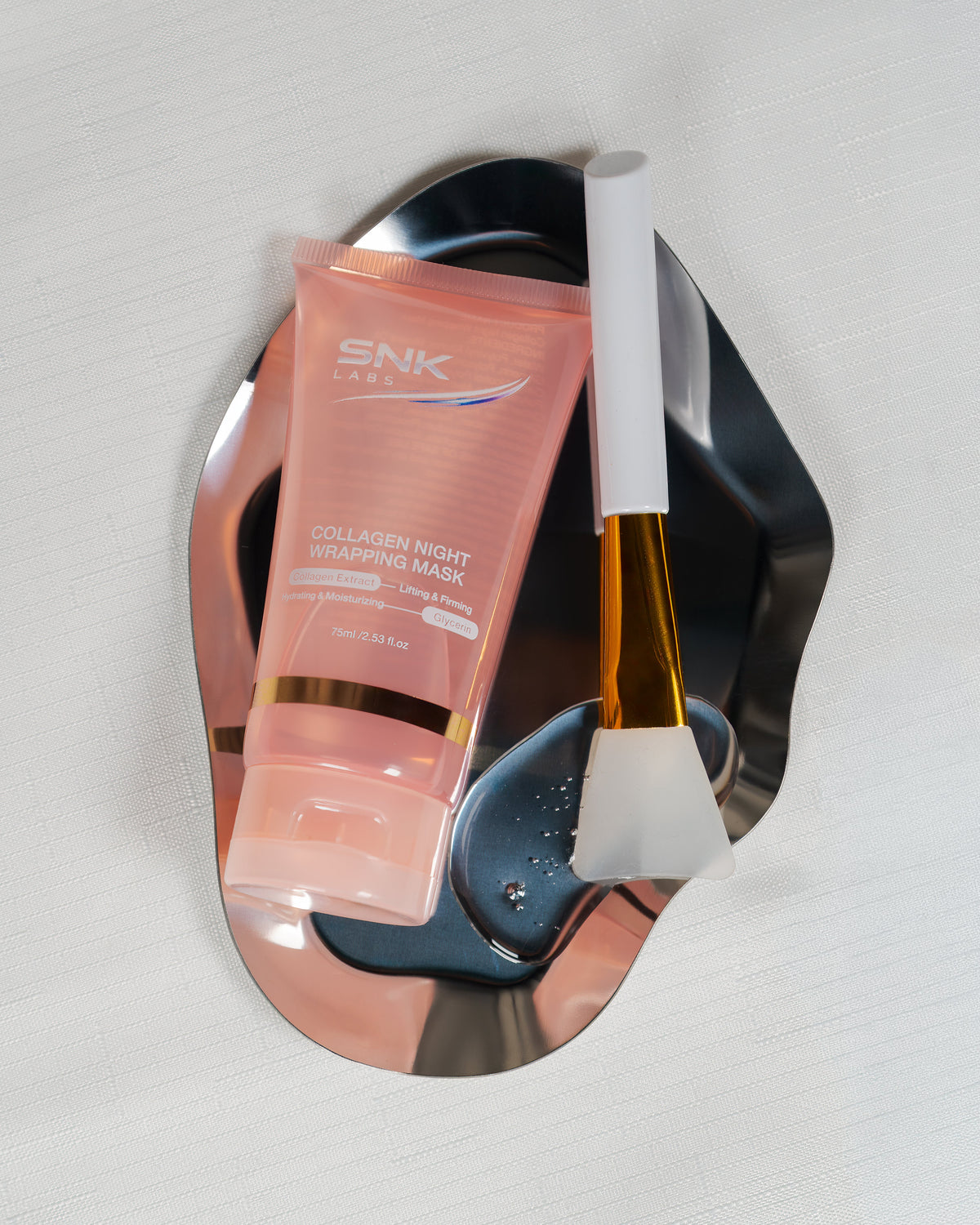 SNK Labs Collagen Night Wrapping Mask and applicator presented on a silver plate