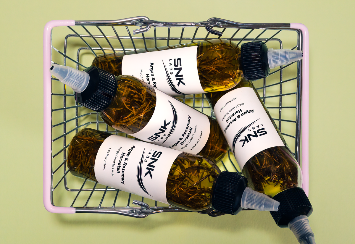 SNK Labs Hair Growth Elixir bottles arranged in a woven basket