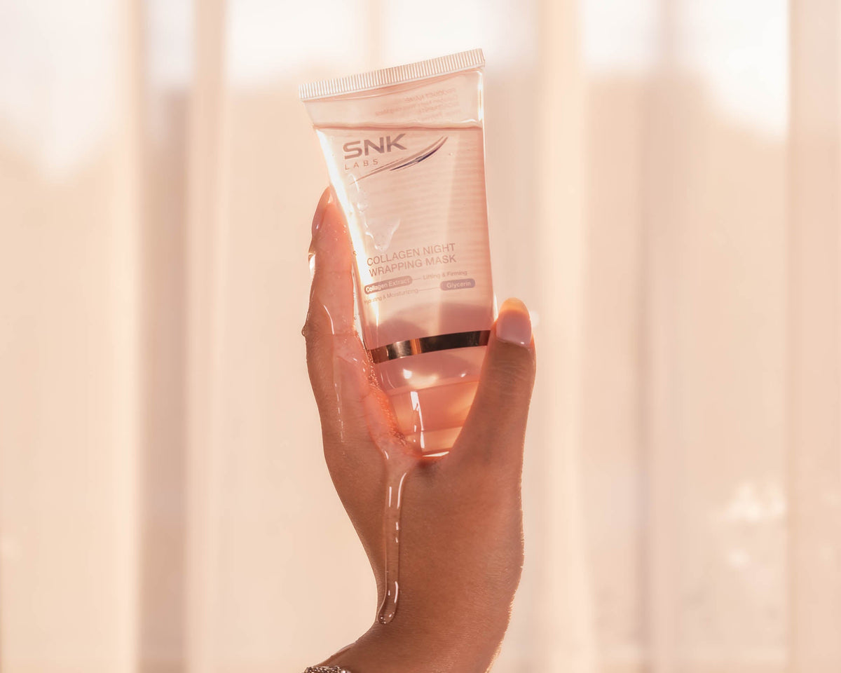 Hand holding the SNK Labs Collagen Night Wrapping Mask against a soft, blurred background