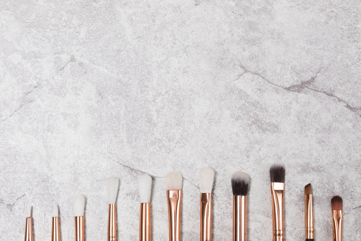Skincare and beauty products arranged on a pale neutral surface